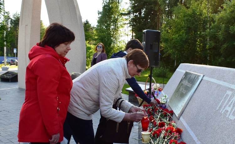 Участники акции возлагают цветы к монументу и зажигают свечи памяти